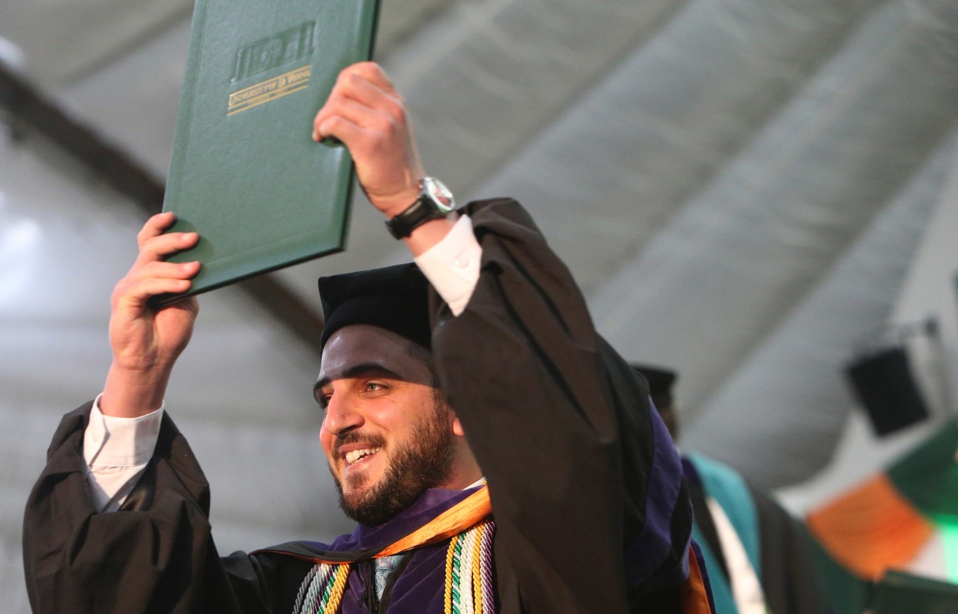 A College of Law graduate smiles onstage