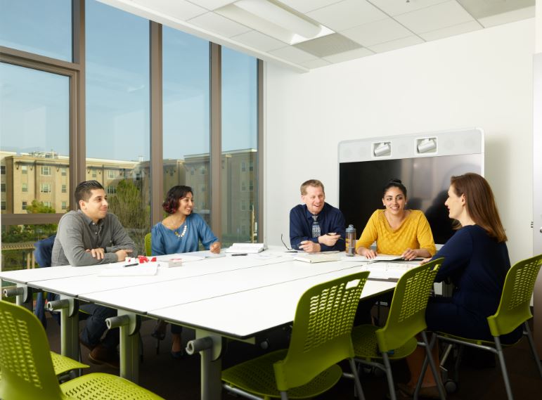 Professor and students gather around a table