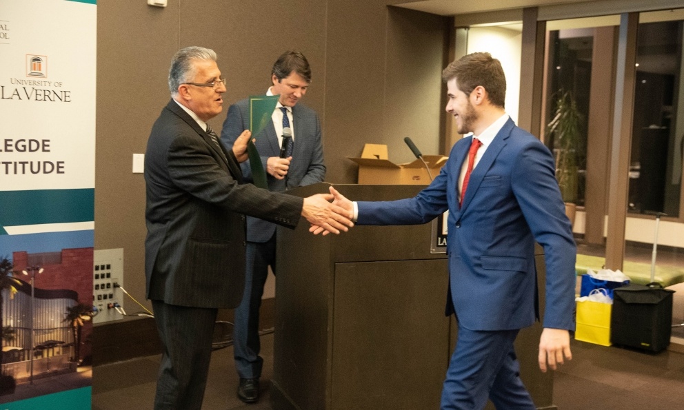 Student shakes hand with professor