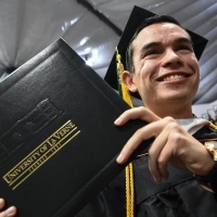 Male student holding diploma