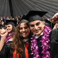 Female and male student holding diplomas