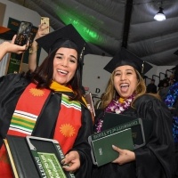 Female students holding diplomas