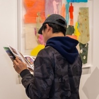 Student reads the artist's catalog