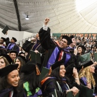 Students cheer at graduation.