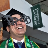 A male student wears "grad" glasses.