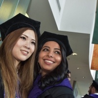 Female students smile in the Michael and Sara Abraham Campus Center after graduation.