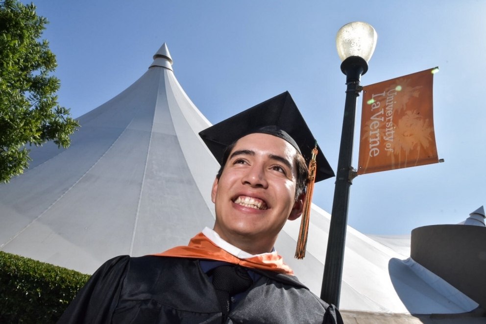 Graduate standing in front of the pavilion