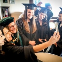Students take photos with university president