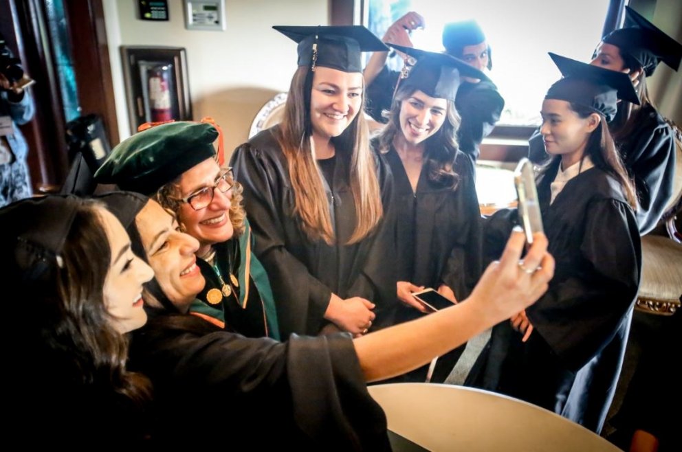 Students take photos with university president