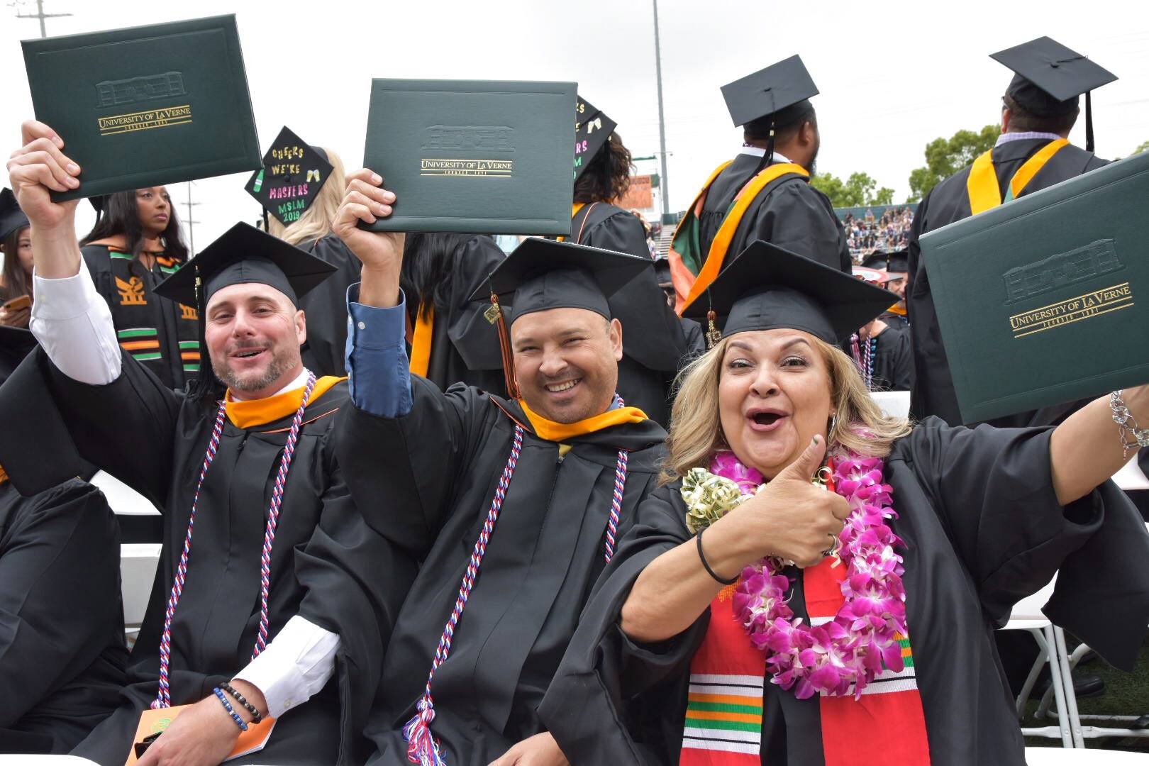 Students holding up their diplomas