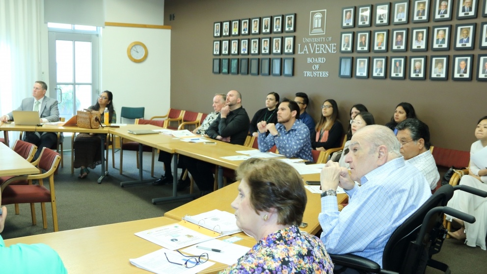 Business leaders listening to student presentations