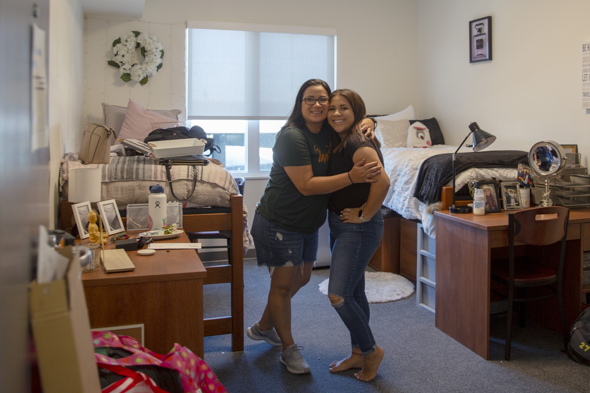 Mom and daughter hug in dorm room