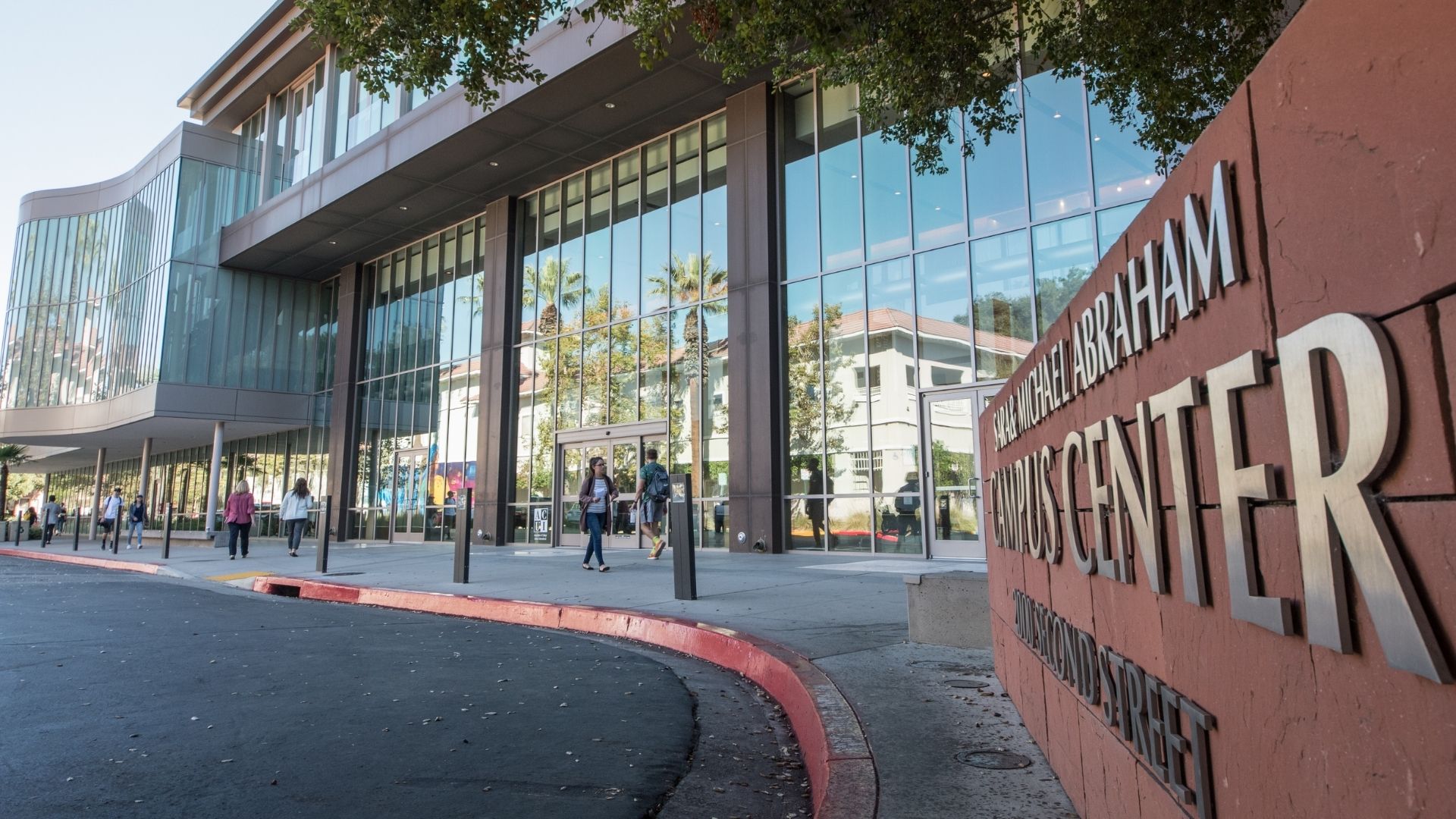 Abraham Campus Center with people walking by, resuming campus activity