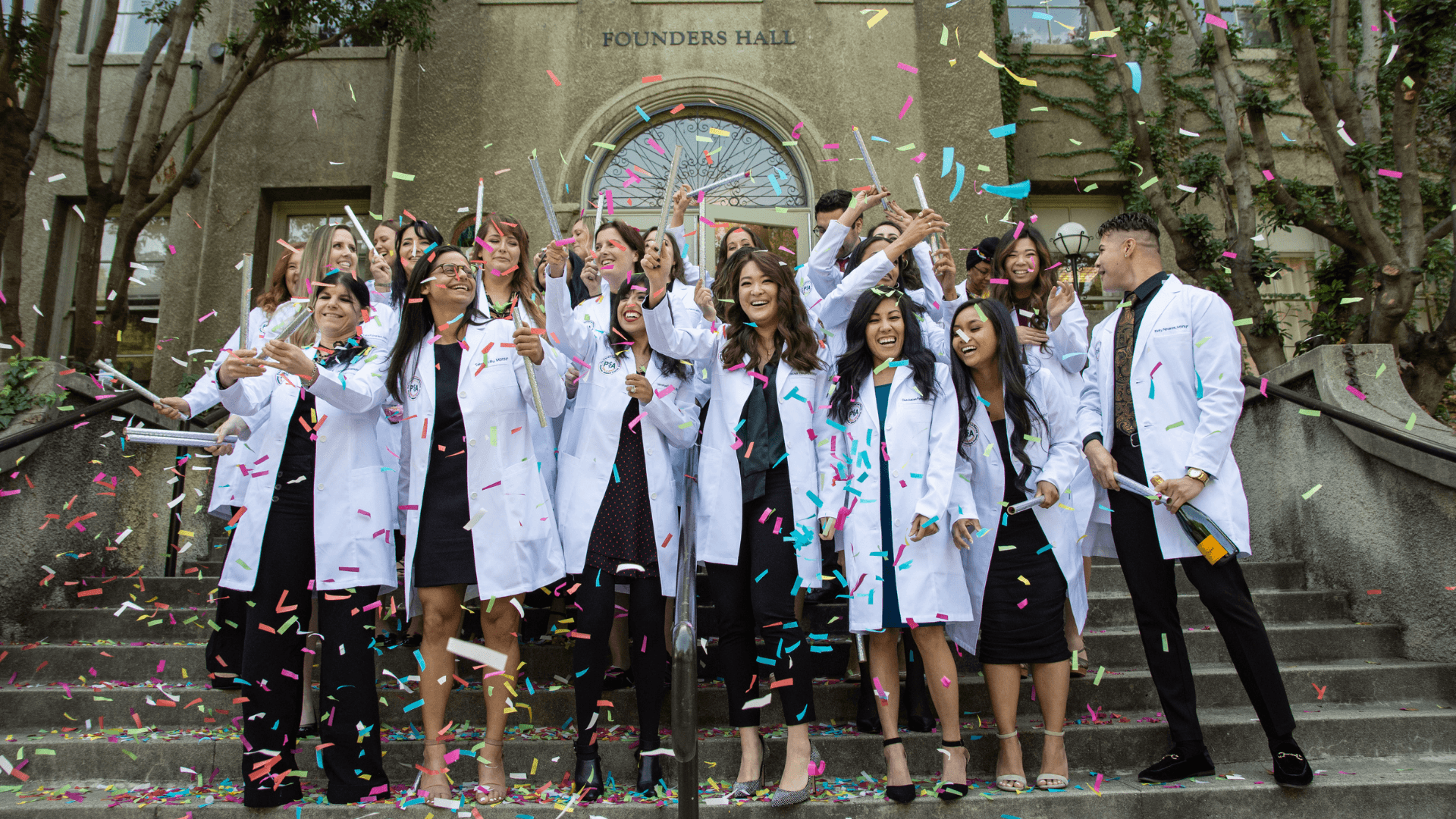Physician Assistant Program Graduates on the steps of Founders Hall celebrating with confetti