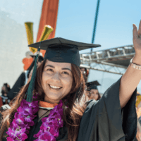 Student waves during commencement ceremonies