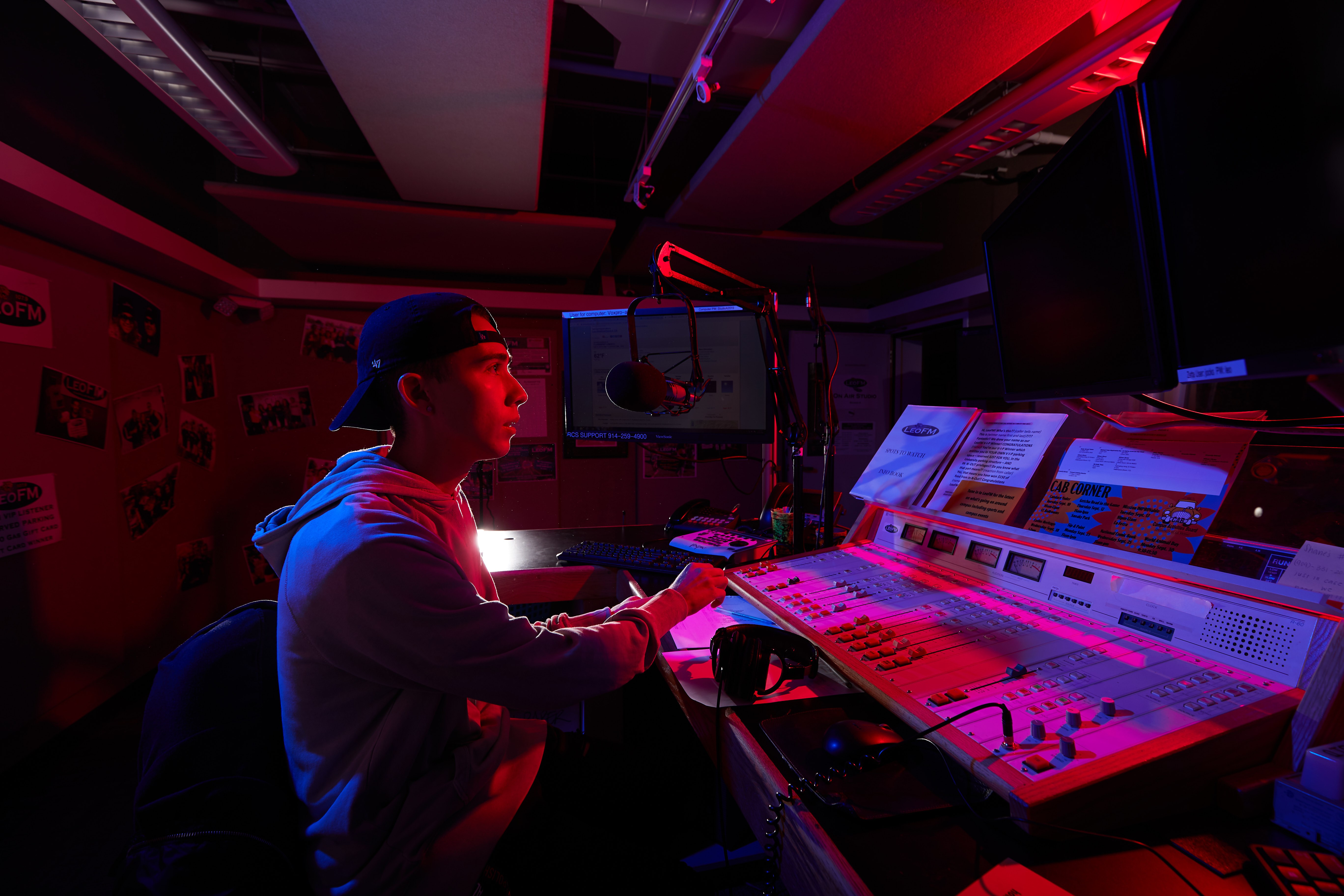 A student works on the audio sound board inside the University of La Verne's LeoFM radio studio.