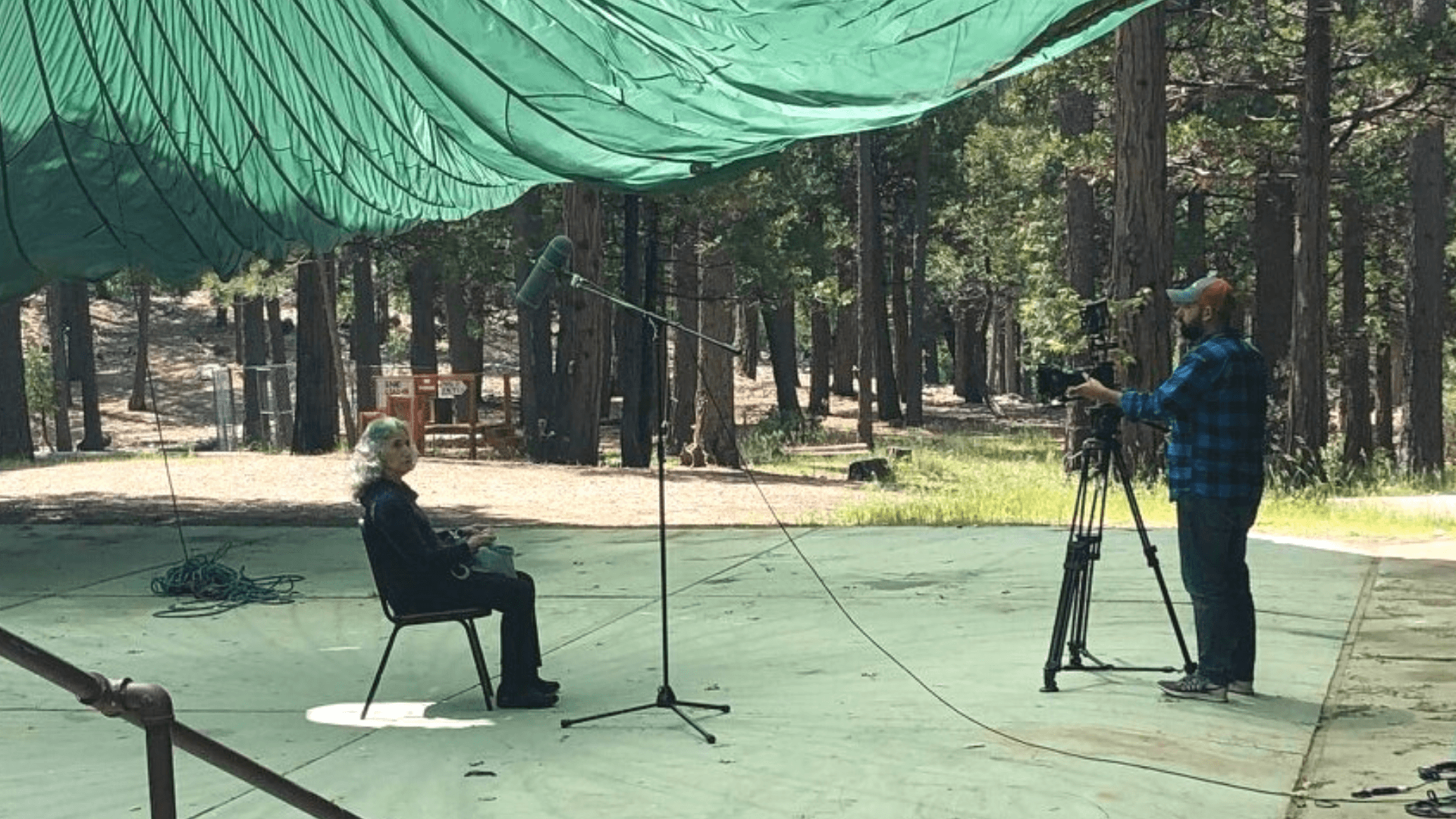 Documentary filming image outside under a tent in the woods