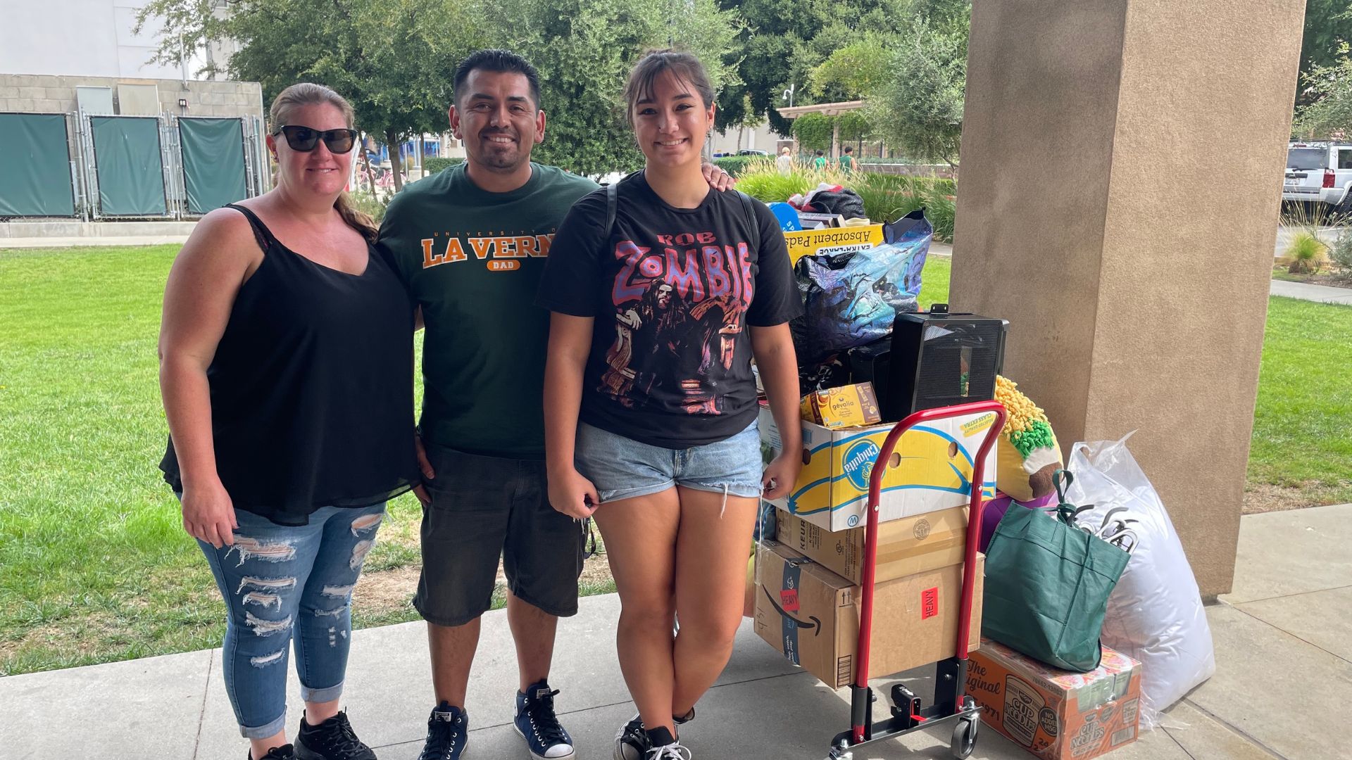 Family posing with housing supplies for Move-In Day 2023