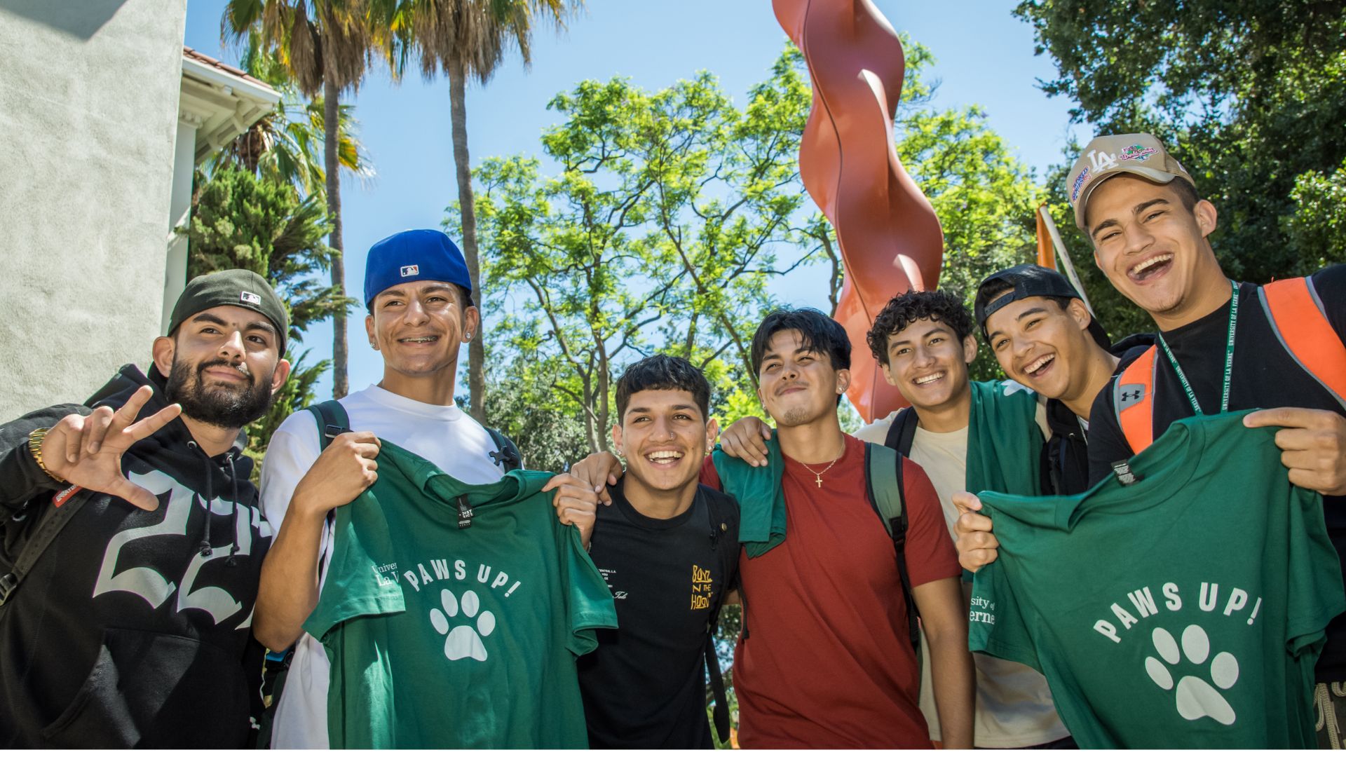 Students smiling in a group with paws up t-shirts during 2023-2024 convocation ceremony