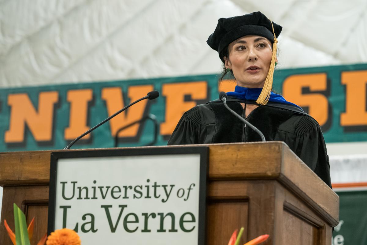 Professor of Marketing Astrid Keel at the podium speaking in regalia for Convocation