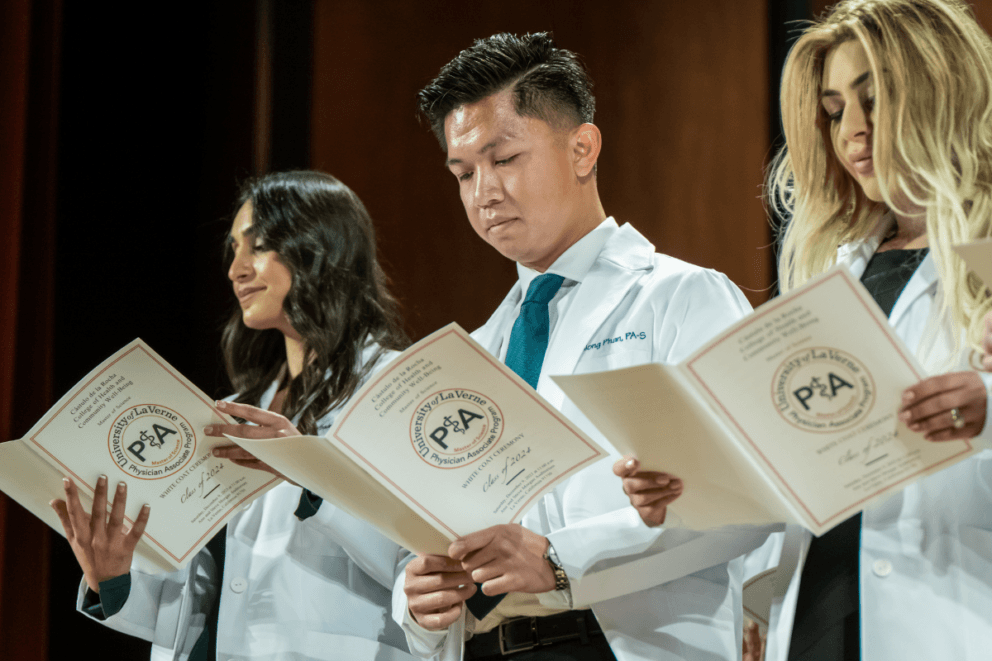 2023 White Coat Ceremony students on stage reading from oath