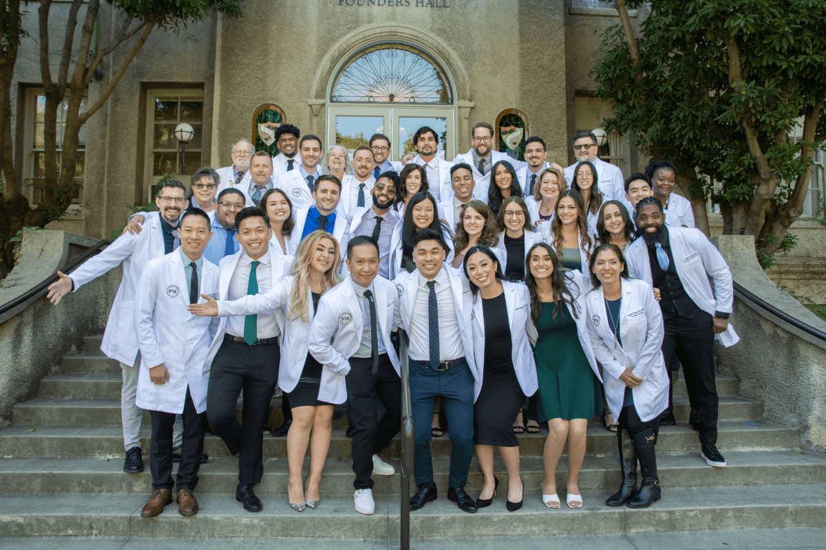 PA Program White Coat Ceremony on Founders Hall Stairs posing together as a cohort