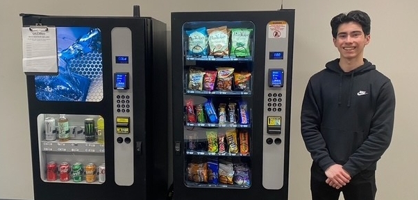 Anthony Garrido standing by vending machines